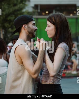 Coppia giovane che si tiene per mano e si guarda l'un l'altro Foto Stock