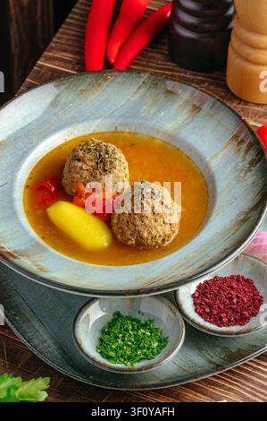 Zuppa sostanziosa di polpette in una ciotola rustica con spezie Foto Stock
