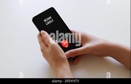 Schermo dello smartphone che mostra una chiamata in arrivo da un chiamante sconosciuto. Foto Stock