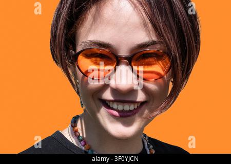 Ritratto ravvicinato di una giovane donna felice che sorride naturalmente mentre guarda direttamente la fotocamera. Volto femminile autentico con emozioni positive, sano Foto Stock