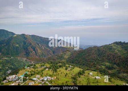 Una vista aerea cattura le vaste catene montuose verdi e il paesaggio boschivo fitto vicino al lago Kareri nell'Himachal Pradesh. Foto Stock