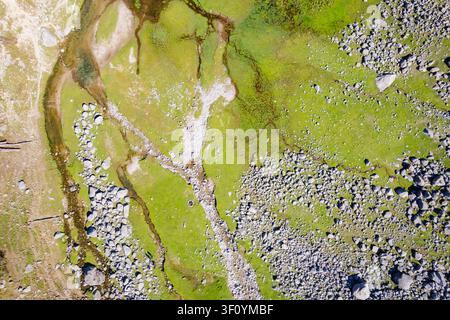 Una vista aerea delle vivaci praterie verdi e del paesaggio roccioso che circondano il lago Kareri a Dharamshala, in India. Foto Stock