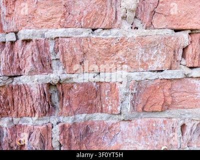 Vecchio muro di mattoni rossi con crepe visibili Foto Stock