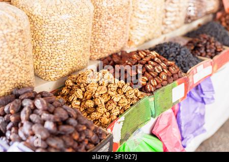 Noci e frutta secca esposti al bazar di Siab a Samarcanda. Noci, pistacchi, datteri e uvetta disposti in scatole e sacchi in un mercato all'aperto Foto Stock