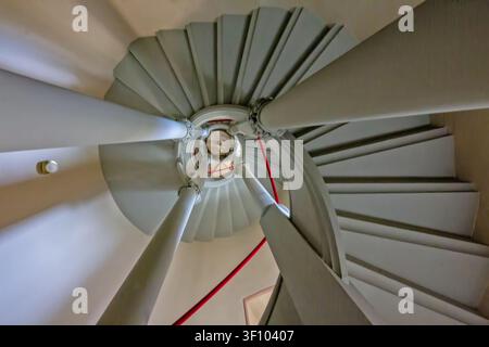 Guardando verso l'alto attraverso l'elegante scala a chiocciola all'interno del castello di Hohenzollern, che mostra una simmetria architettonica notevole, arte della pietra e Foto Stock