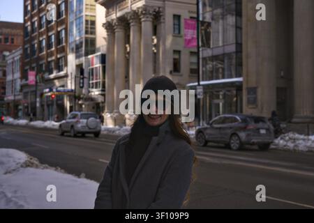 Donna in cappotto invernale posa su una strada storica di Toronto, Canada, il 4 febbraio 2026 Foto Stock