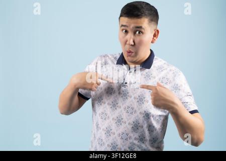 Giovane uomo che punta il dito verso se stesso mostrando un'emozione di sorpresa Foto Stock