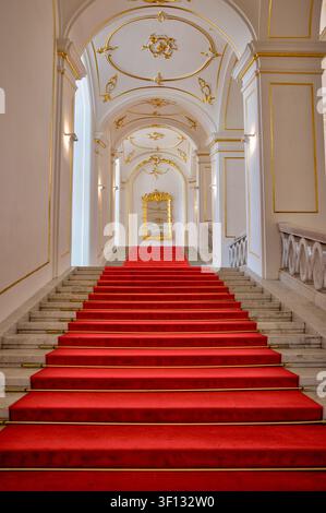 Grande scalinata cerimoniale rivestita di moquette rossa all'interno del castello di Bratislava a Bratislava, Slovacchia. Foto Stock