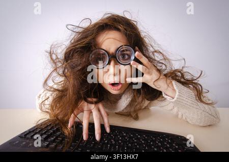 Funny nerd ragazza che lavora sul computer Foto Stock