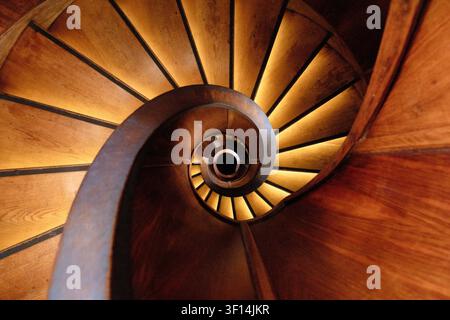 Scalinata a chiocciola in legno che forma un motivo geometrico all'interno di un edificio storico nel centro di Lubiana, in Slovenia. Foto Stock