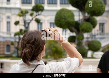 Donna che utilizza lo smartphone per scattare foto, vista posteriore Foto Stock