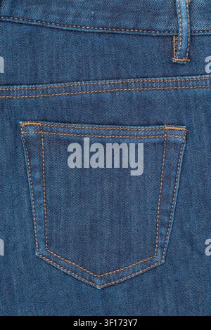 Vista ravvicinata della tasca posteriore di un classico jeans di denim blu. Presenta cuciture arancioni dettagliate, passante per la cintura e texture del tessuto. Fondo ideale per la moda Foto Stock