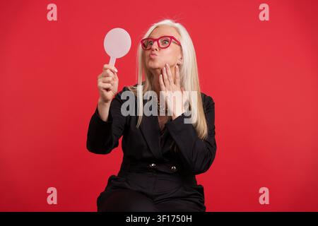 Anziana che controlla il suo riflesso che invecchia bene Foto Stock