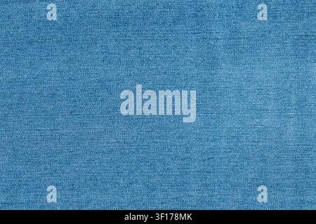 Prima vista di tessuto denim blu con motivo di trama visibile e variazioni di texture sottili. Un'illuminazione uniforme mette in risalto i dettagli delle fibre naturali. Ideale per la moda Foto Stock