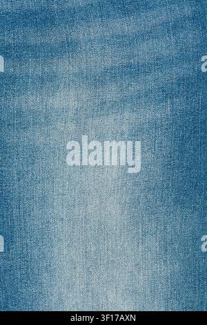 Macro dettagliata di tessuto denim blu chiaro. Struttura di jeans consumato con classica trama diagonale a saia. Il materiale di cotone sbiadito costituisce uno sfondo ideale Foto Stock