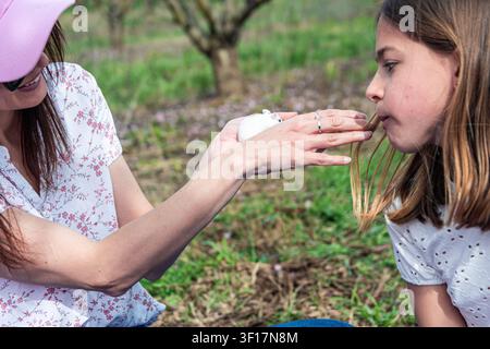 Madre e figlia che passano del tempo con il loro criceto domestico all'aperto Foto Stock