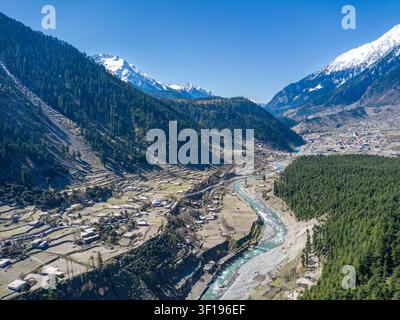Vista aerea della foresta di Ushu e del fiume Swat che scorre attraverso la valle con campi terrazzati e montagne innevate sullo sfondo a Kalam, Kh Foto Stock