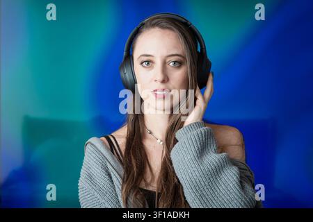 Giovane donna concentrata che gode di un audio immersivo attraverso cuffie senza fili Foto Stock