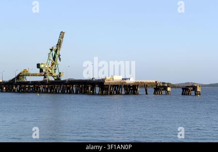 Un grande sistema di gru di scarico industriale e nastri trasportatori in funzione al terminale carbone RG Tanna del porto di Gladstone, Queensland, Australia Foto Stock