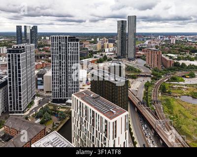 Vista aerea dello skyline moderno di Manchester con grattacieli residenziali, binari ferroviari e sviluppo urbano a Manchester, Inghilterra Foto Stock
