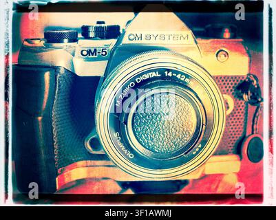 Prima stilizzata sovraprocessata di una fotocamera mirrorless OM System OM5 con obiettivo Olympus 14-42mm caratterizzata da un effetto bordo film vintage Foto Stock