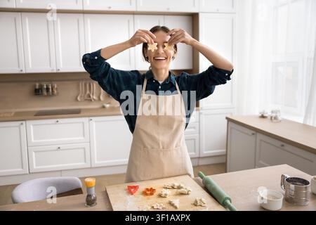 Donna che si diverte, crea occhiali con pezzi di impasto a forma di stella Foto Stock