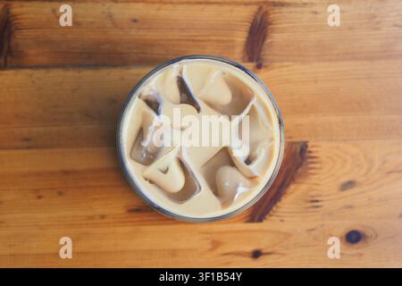 Caffè freddo con latte servito in un bicchiere su un tavolo di legno Foto Stock