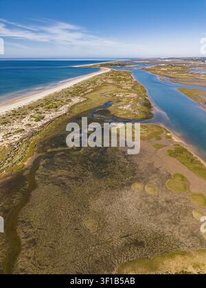 Vista aerea del paesaggio costiero a Cabanas con spiagge di sabbia, canali di marea e paludi salate a Cabanas, Faro, Portogallo. Foto Stock