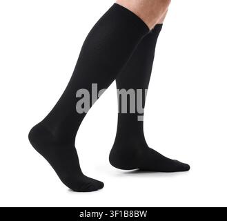 Persona che indossa calzini di compressione neri per supporto medico e una migliore circolazione, isolata su sfondo bianco, Questi calzini sono progettati per il tallone Foto Stock