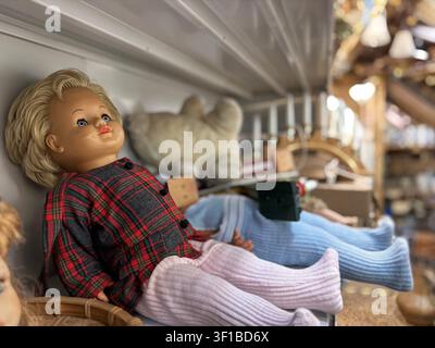 Bambole vintage e peluche su scaffali Foto Stock