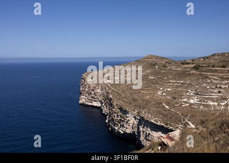 Maestose scogliere di calcare che si estendono nel profondo mare mediterraneo blu a Malta. Foto Stock
