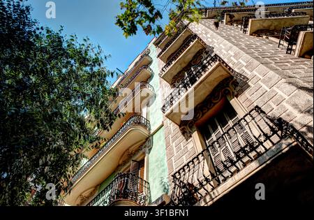 Facciate residenziali storiche con balconi in ferro battuto visti dal basso su una strada di Barcellona, Spagna. Foto Stock