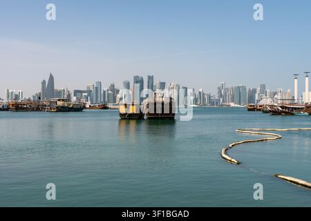 Doha, Qatar - 1 febbraio 2026: Una vista grandangolare del pomeriggio di tradizionali barche di legno dhow ormeggiate nel porto della Corniche di Doha. Foto Stock