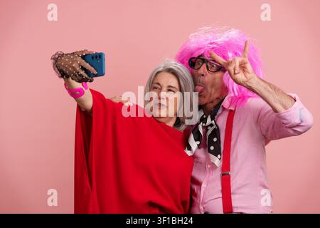 Coppia matura che scatta un selfie divertente celebrando la longevità positiva Foto Stock