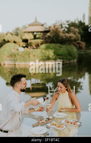 Una coppia si gode una serata giocosa e gioiosa vicino al lago tranquillo. Foto Stock