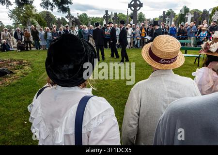 Una rievocazione del Bloomsday del funerale di Paddy Dignam nel cimitero di Glasnevin, Dublino, che mostra attori in costume edwardiano e una folla di spettatori. Foto Stock