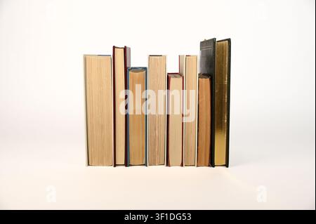 Primo piano di una fila di libri vintage con bordi delle pagine invecchiati Foto Stock