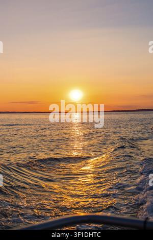 Luce del tramonto su un mare calmo con onde leggere, Howth, Irlanda Foto Stock