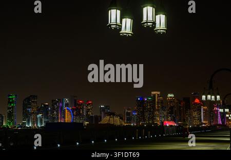 Doha, Qatar. 12 luglio 2026. Una vista dello skyline di Doha e del distretto finanziario di West Bay illuminati di notte dalla passeggiata della Corniche a Doha, Qatar, il 12 luglio 2026. Dopo l'annuncio della morte dell'ex Emiro del Qatar, Sheikh Hamad bin Khalifa Al Thani, all'età di 74 anni, il paese dichiara quattro giorni di lutto ufficiale. Gli edifici governativi e i monumenti della capitale abbassano le bandiere a mezz'asta. (Foto di Noushad Thekkayil/NurPhoto) Credit: NurPhoto SRL/Alamy Live News Foto Stock