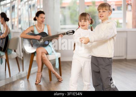 Lezione di danza per bambini con musica di chitarra dal vivo in studio Foto Stock