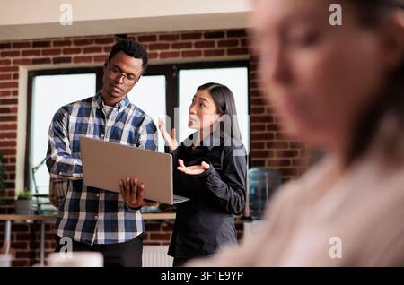 Gli sviluppatori di software analizzano file crittografati alla ricerca di malware mentre monitorano la larghezza di banda Internet e la sicurezza dei dati in un'agenzia di cybersecurity. Foto Stock