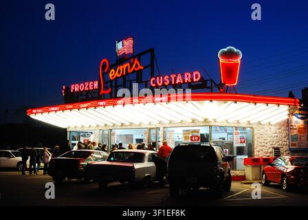 Le auto sono parcheggiate davanti al Leon’s Frozen Custard, e il diner storico iconico degli anni '50 e gelateria è illuminato di notte a Milwaukee Foto Stock