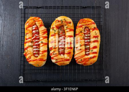 Panino salato con salsiccia e cipolla verde, guarnito con maionese e ketchup Foto Stock