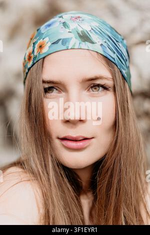 Ritratto di donna foulard primo piano di una bella donna che indossa una bandana floreale all'aperto con sfondo sfocato naturale Foto Stock