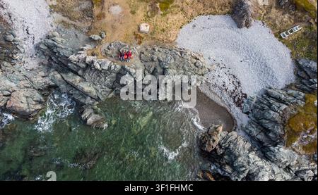 Vista aerea di due persone su una panchina sulla costa rocciosa di Terranova Foto Stock