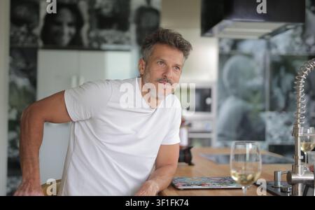 Affascinante uomo di mezza età dall'aria pensierosa in cucina Foto Stock