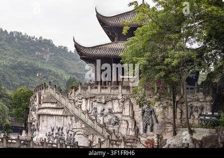 Chongqing, Cina – 10 giu 2026 – Appollaiato su una parete di terrazza rialzata a Chiyou Jiuli City a Pengshui, Chongqing, si trova un grandioso padiglione a struttura lignea Foto Stock