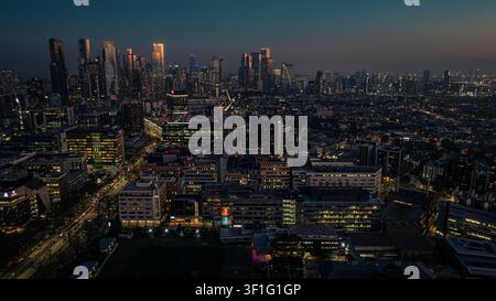 Vista aerea dello skyline di Melbourne di notte con grattacieli illuminati, strade cittadine luminose e densità urbana a Parkville, Victoria, Australia. Foto Stock