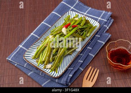 Spinaci d’acqua saltati con aglio Piatto tradizionale cantonese e vegetale del Sud-Est asiatico Foto Stock