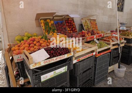 Stand di mercato all'aperto che vende vari frutti estivi maturi e colorati come albicocche, pesche, ciliegie e uva. Italia, Bari, 21 luglio 2025 Foto Stock